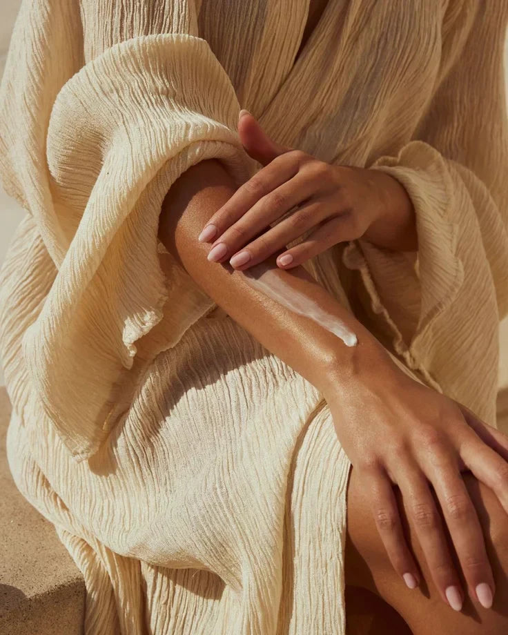 Photo d'une femme appliquant de la crème hydratante sur sa peau